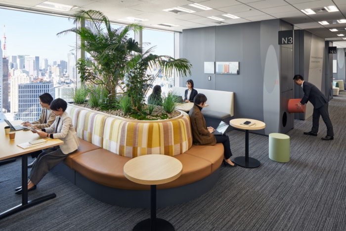 Modern office breakout area with natural light and people working